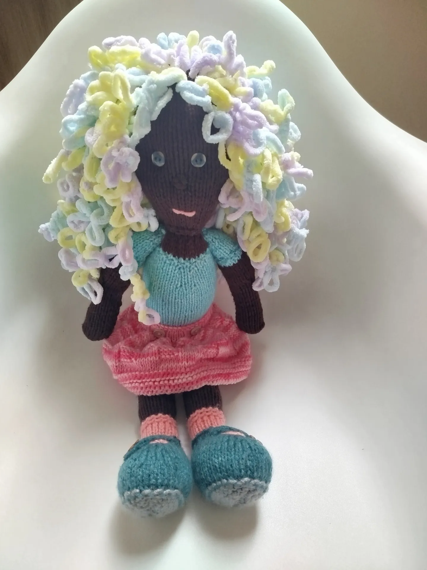 Muñeca tejida a mano. Piel oscura, ojos grises y beige