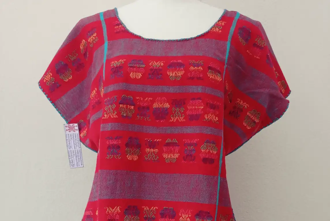 Huipil rojo, brocados multicolores matizados, toque turquesa.