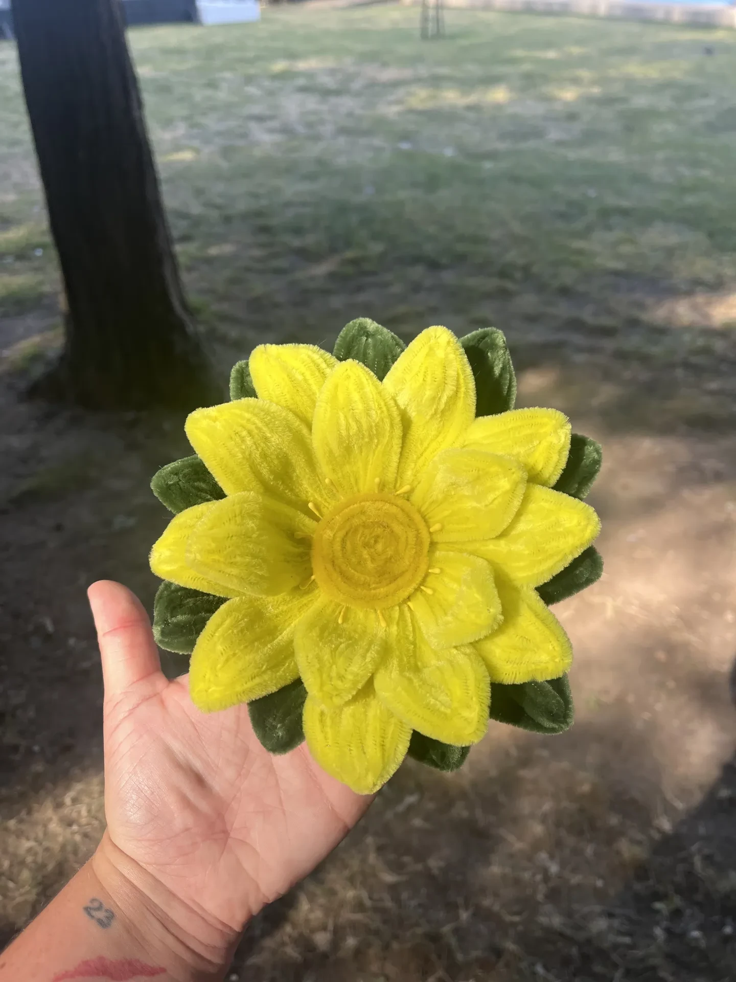 Flor de loto hecha con limpiapipas con base de madera